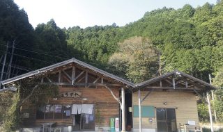 2棟並んだ木造の建物。すぐうしろには山がせまっている