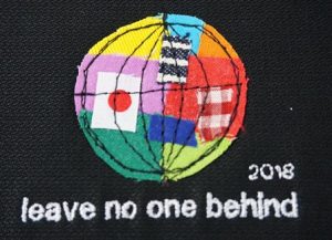 ミシンで刺繍された地球。日本のほかさまざまな国旗、色が組み合わさっている。