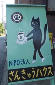さんきゅうハウスの看板。黒い猫が珈琲カップをもっている。